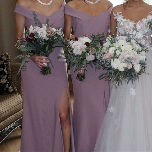 three bridesmaids in purple dresses holding bouquets