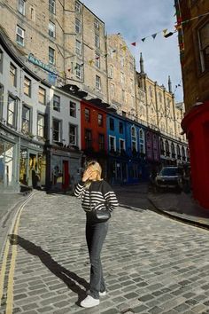 a woman standing in the middle of a cobblestone street