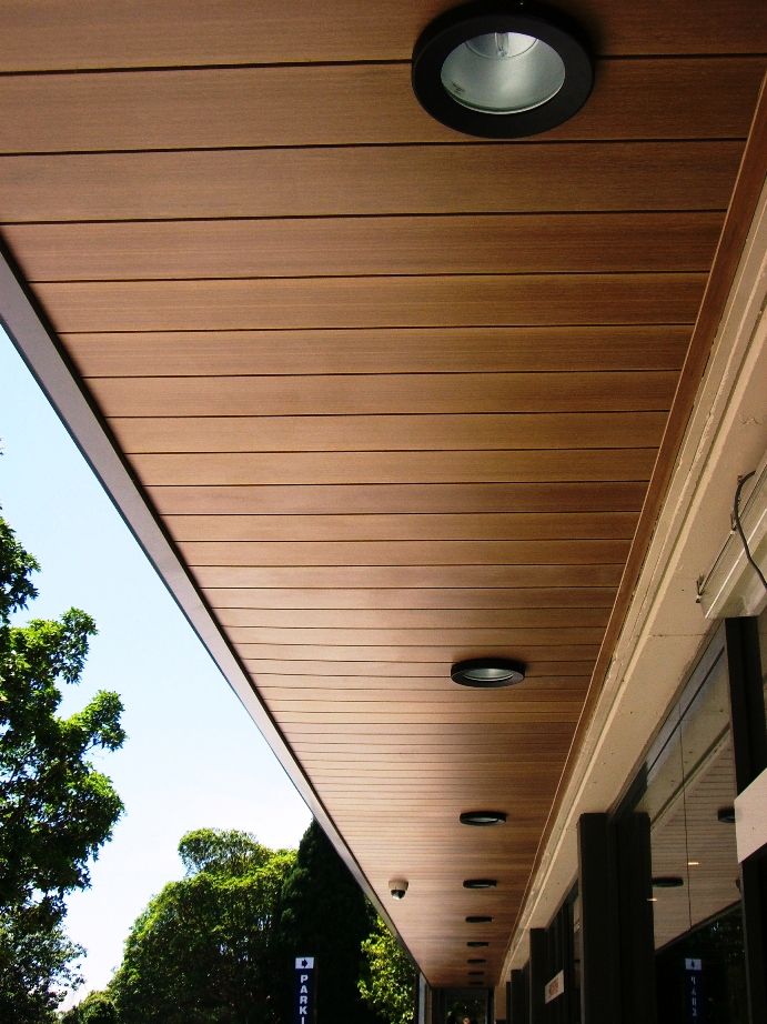 an outside view of a building with lights on the ceiling