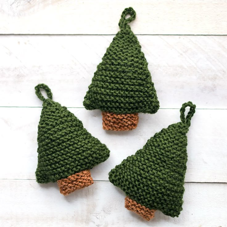 three crocheted christmas tree ornaments are shown