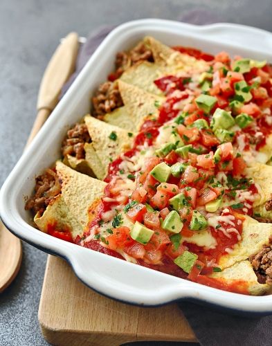 a white casserole dish filled with meat and veggies