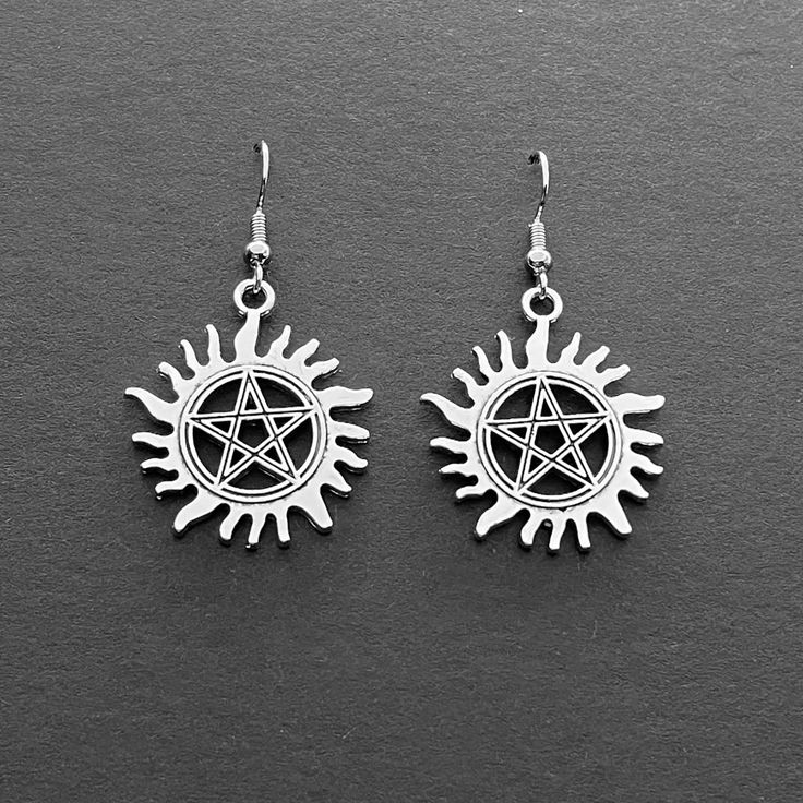 Wear the Supernatural Winchester boys' anti-demon protection tattoo in a stylish pair of earrings for peace of mind at all times ^_- Each silver tone sigil charm is 2.5cm (1") in diameter and hangs from a standard 304 stainless steel earring wire; the charms are free from nickel, lead and cadmium. As with all items of metal jewelry, avoid contact with perfumed products, hairsprays, lotions, chlorine, saltwater etc. as these are damaging to metals. We recommend removing earrings before swimming, Protection Tattoo, Supernatural Tattoo, Sam And Dean, Sam And Dean Winchester, Replica Jewelry, Winchester Boys, Earring Wire, Replica Prop, Jewelry Card