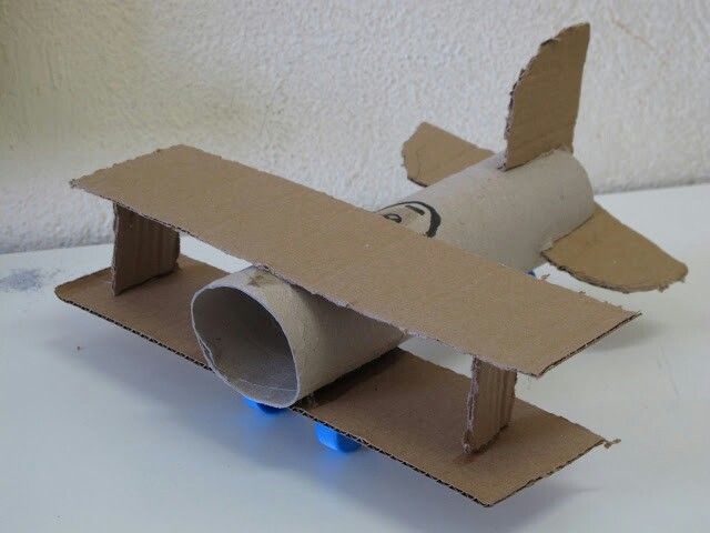 an airplane made out of cardboard sitting on top of a table