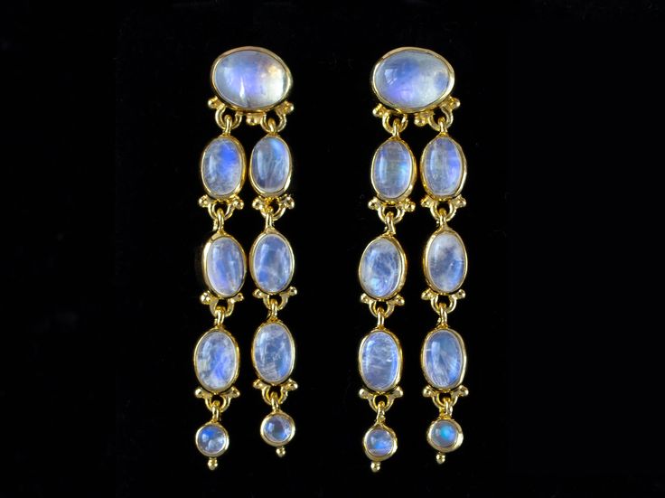 "These Gold Moonstone dangle earrings are a testament to craftsmanship and elegance, featuring 18 opulent Rainbow Moonstones dangling in handcrafted 18K Gold Vermeil settings. Luxurious, exquisite, and dramatic. The larger Rainbow Moonstones are delicately set in secure post-back settings. Adding an element of movement and grace, 16 Moonstones elegantly dangle below, creating a cascade of luminous beauty. Each stone is carefully selected to ensure its radiance and allure, with meticulous attention to detail. Handcrafted with passion, these earrings are designed to enhance any ensemble with their timeless elegance. Whether you're embellishing yourself at your wedding or wearing them for a night on the town, these earrings will make you feel like a goddess. 18K Gold paired with Rainbow Moons Gold Dangle Earrings With Moonstone, Gold Multi-stone Moonstone Jewelry, Luxury Moonstone Drop Earrings, Gold Moonstone Dangle Crystal Earrings, Yellow Gold Moonstone Dangle Earrings, Rainbow Moonstone Jewelry, Gold Vermeil Jewelry, Moonstone Earrings, Vermeil Jewelry