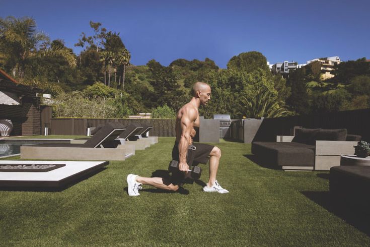 a shirtless man is doing exercises on the grass