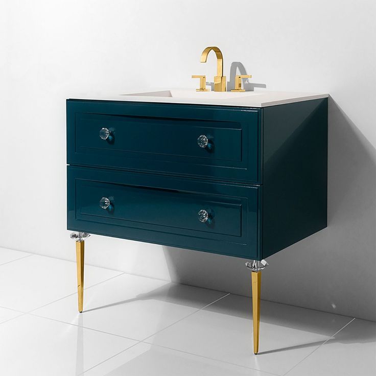 a bathroom vanity with two drawers and a gold faucet on the top, against a white wall