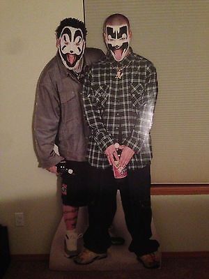 two people with painted faces standing next to each other in front of a wall and window