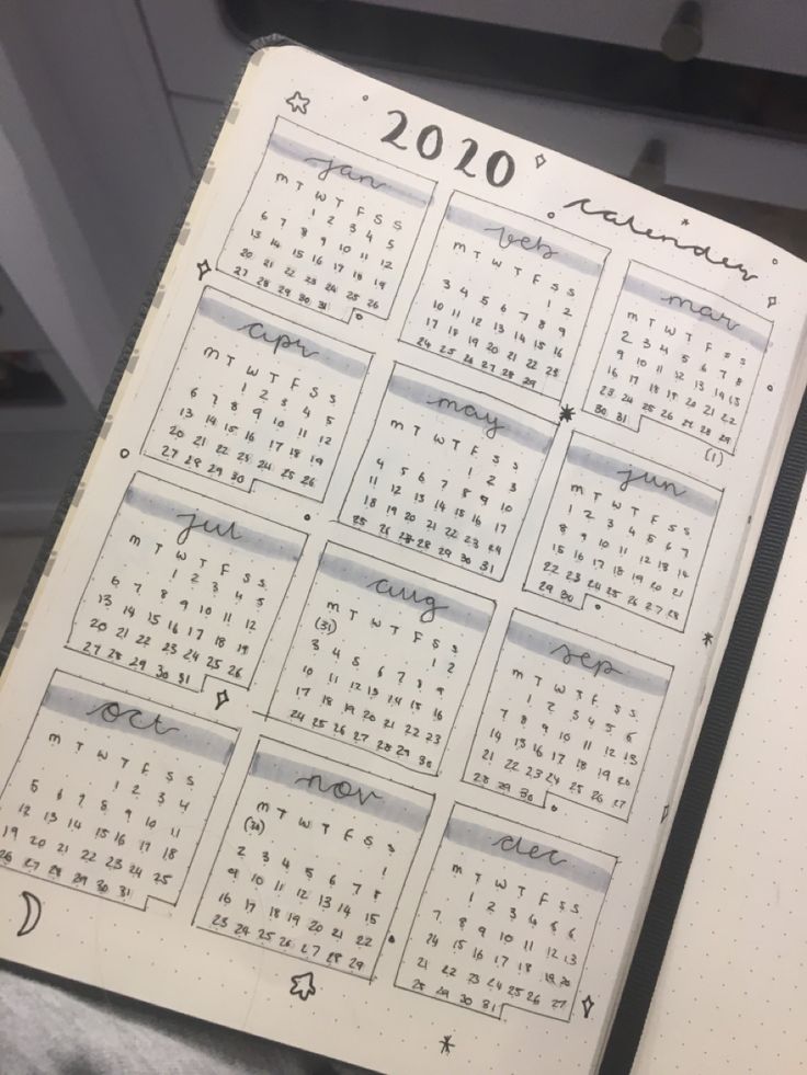 a calendar is open on top of a notebook with writing in the pages and numbers