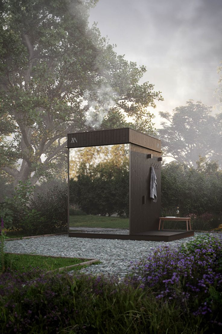 a small wooden structure sitting in the middle of a garden with purple flowers around it