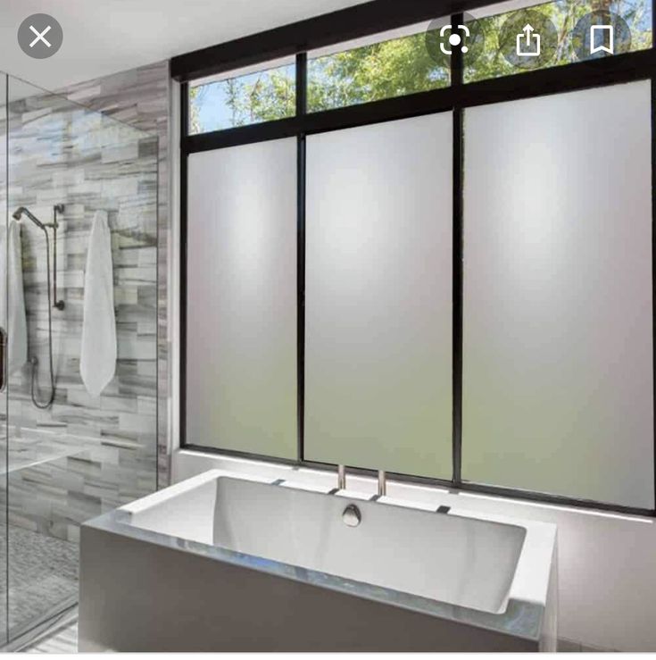 a bathroom with a large bathtub next to a walk in shower and glass doors