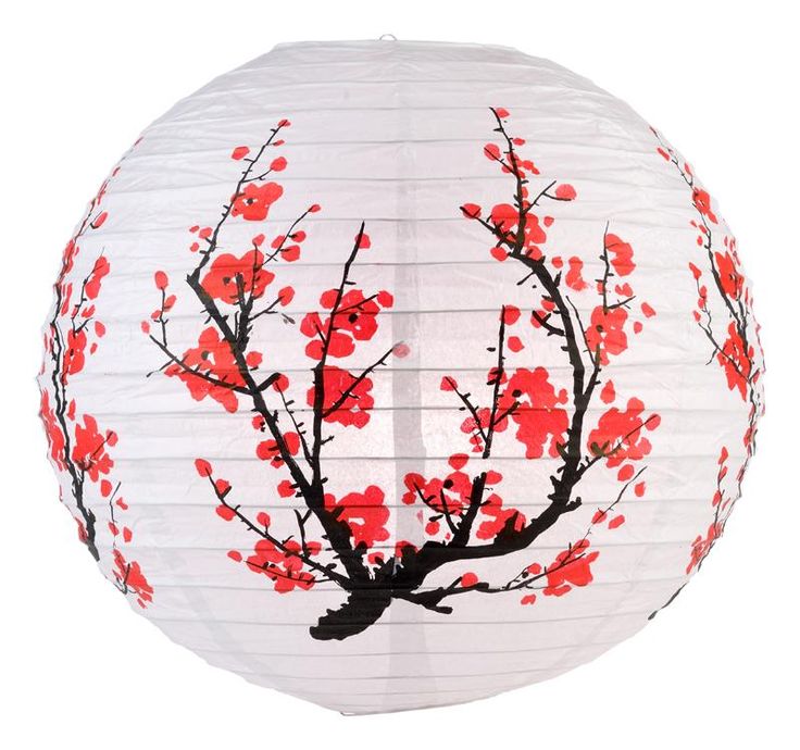 a white paper lantern with red flowers painted on the bottom and branches in the middle