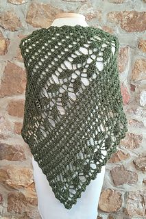 a green crocheted shawl on top of a mannequin head