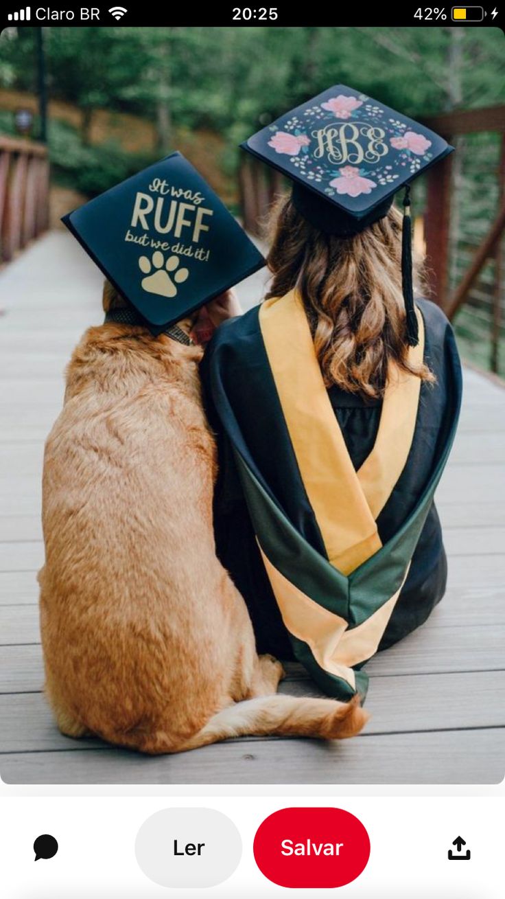 a dog wearing a graduation cap and gown sitting next to a cat on a deck