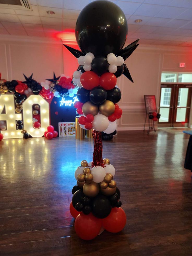 a balloon tower is decorated with black, white and red balloons