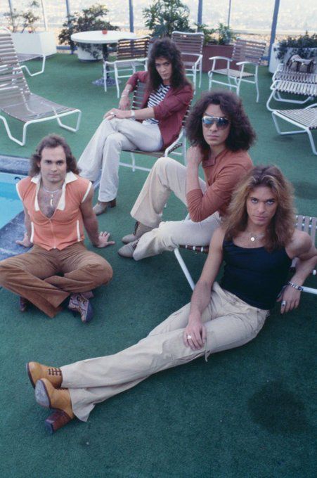 four women sitting next to each other in front of a swimming pool