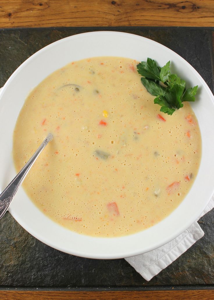 a white bowl filled with soup and garnished with parsley on the side