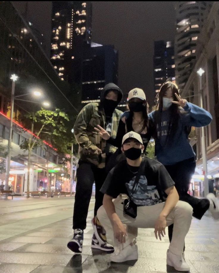 four people posing for a photo in the city at night