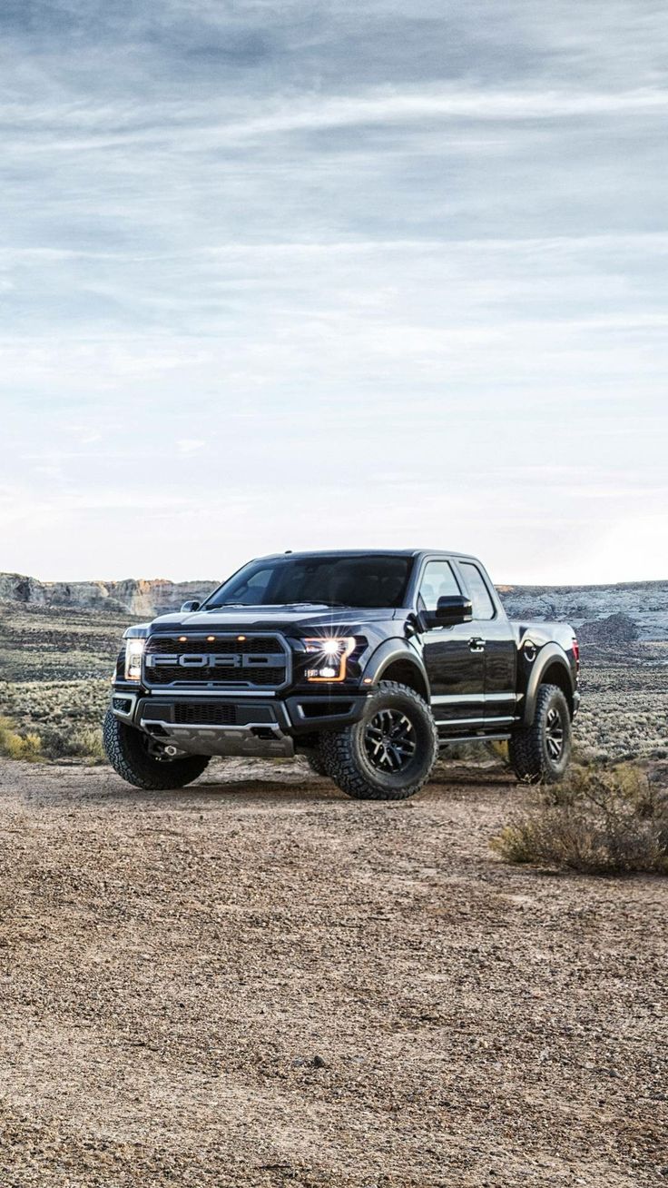 two pickup trucks parked in the desert