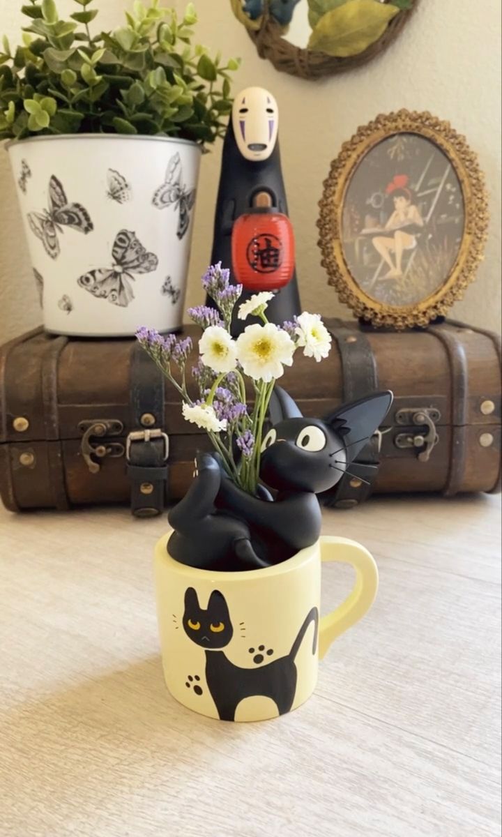 a black and white cat mug with flowers in it