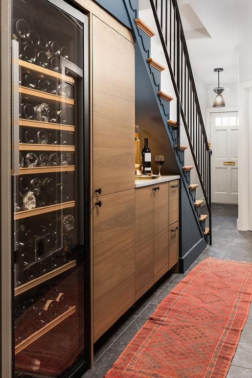 a wine cellar under the stairs in a home