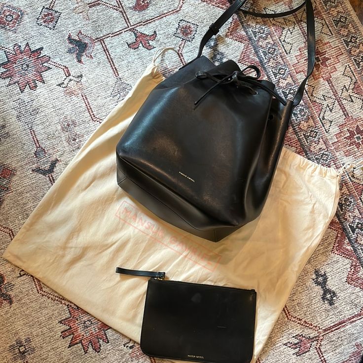 The Style That Started It All Our Iconic Mansur Gavriel Bucket Bag Can Be Worn Cinched Or Open, Accommodating Everything From Overnight Essentials To A Small Laptop. It's Made From High Quality Vegetable-Tanned Leather That Is Sourced From A Family-Owned Tannery In Italy And Intended To Age Naturally Over Time, Growing In Character The More You Use It. 23cm X 31cm X 16.5cm Composition: 100% Italian Cow Leather Made In Italy Our Italian Vegetable Tanned Leather Is A Classic Leather That Shows Its Wear Beautifully Over Time. It Will Not Remain Pristine And Sleek, And Although Scratching Will Occur, We Do Not View These Marks As Defects. The Patina Created By Daily Wear-And-Tear Is Mea Overnight Essentials, Mansur Gavriel Bucket Bag, Age Naturally, Mansur Gavriel Bag, Black Bucket Bag, Black Bucket, Small Laptop, Mansur Gavriel, Classic Leather