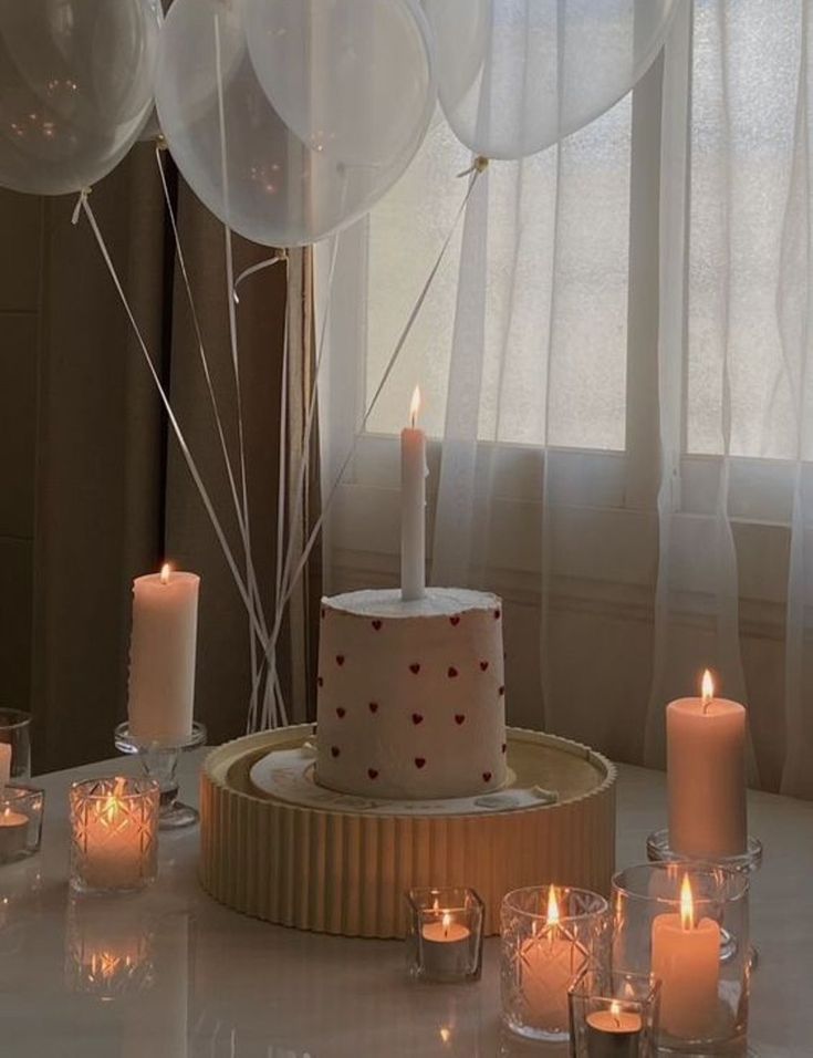 a birthday cake surrounded by candles and balloons