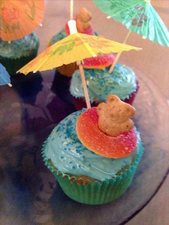 cupcakes with umbrellas and teddy bears on them are ready to be eaten