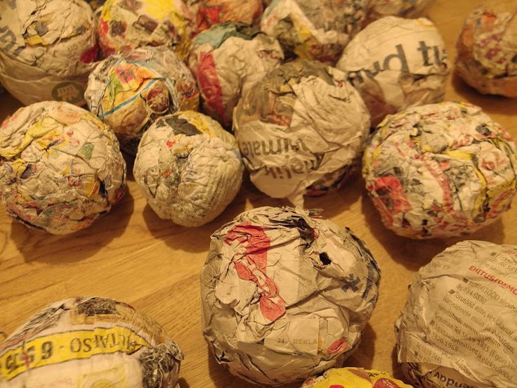 many balls of paper are sitting on a table with tape wrapped around them and some have writing on them