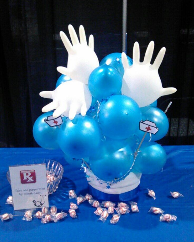 blue and white balloons are in a bucket on a table with silver confetti