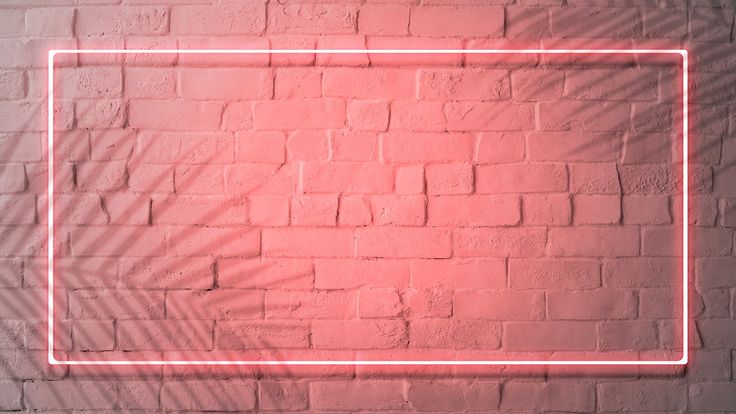 a pink neon frame on a brick wall with palm leaves in the corner and shadow