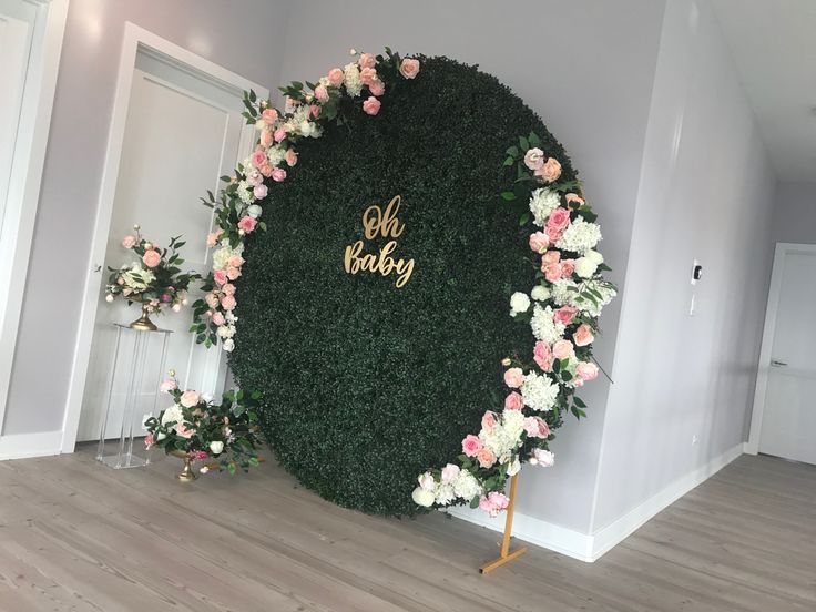 a floral backdrop with the word oh baby written on it in gold lettering and pink flowers