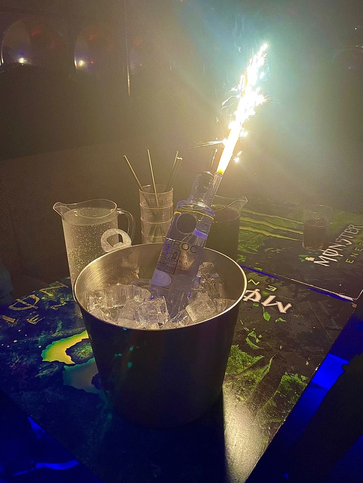 a table topped with two glasses filled with liquid and sparklers on top of it