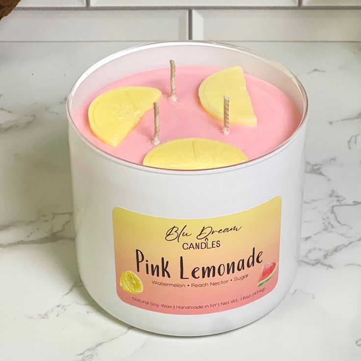 a pink lemonade candle in a white container