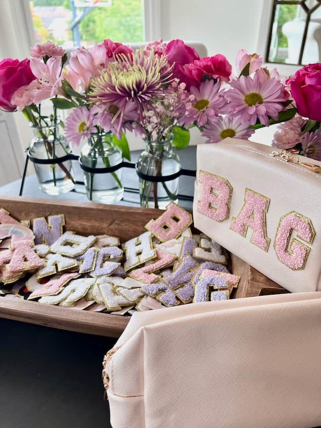 pink and purple flowers are in vases on a table next to cookies that spell out the word dad