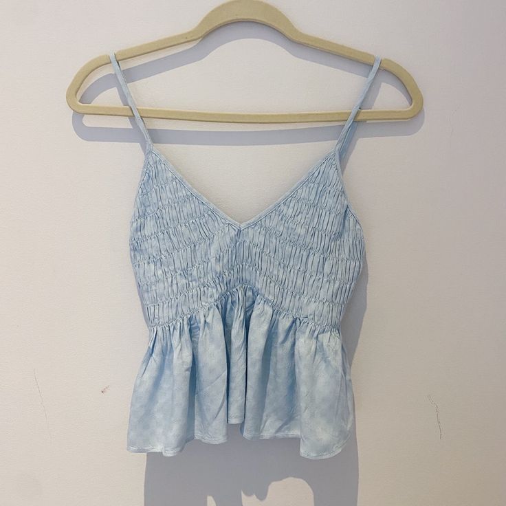 Condition: Never Before Worn, Original Tags Intact Style: Sleeveless Pastel Blue Tank Top, V-Neck, Ruffle Accents, Ruched Bust, Embroidered Design Brand: Cotton Candy La Fabric: 100% Rayon Size: Us Medium, Fits True To Size, Flexible To Various Bust Sizes Due To Elasticity Completly Sold Out Online V-neck Ruffled Camisole For Vacation, Chic Blue Camisole For Summer, Light Blue Sleeveless Blouse Tank Top For Spring, Chic Blue V-neck Camisole, Light Blue Sleeveless Blouse For Spring, Blue Ruffled Straps Tank Top, Blue Tops With Ruffled Straps, Blue Cotton Tank Top With Ruffles, Blue Ruffled Cami Tank Top