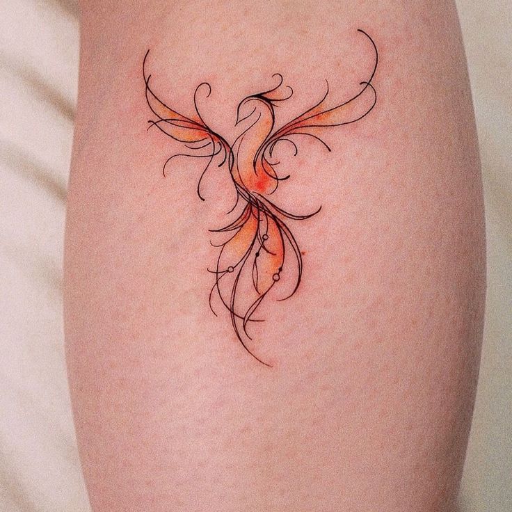 a woman's thigh with an orange bird tattoo on it