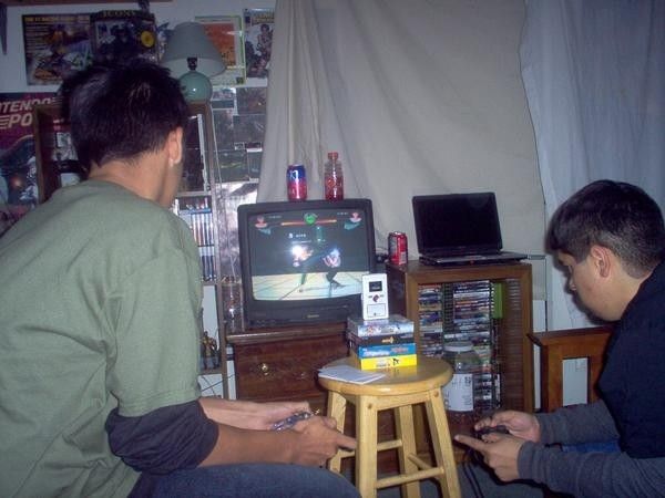 two men sitting in front of a tv playing video games