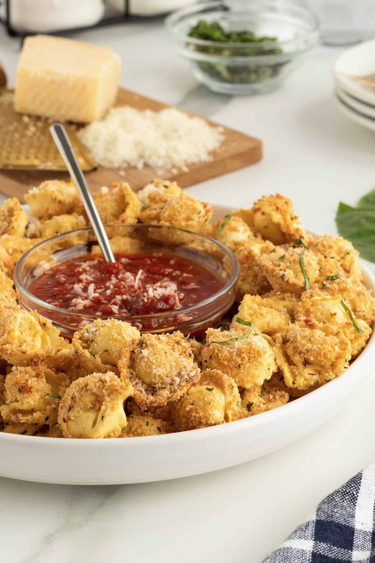 a white plate topped with fried tater tots covered in ketchup