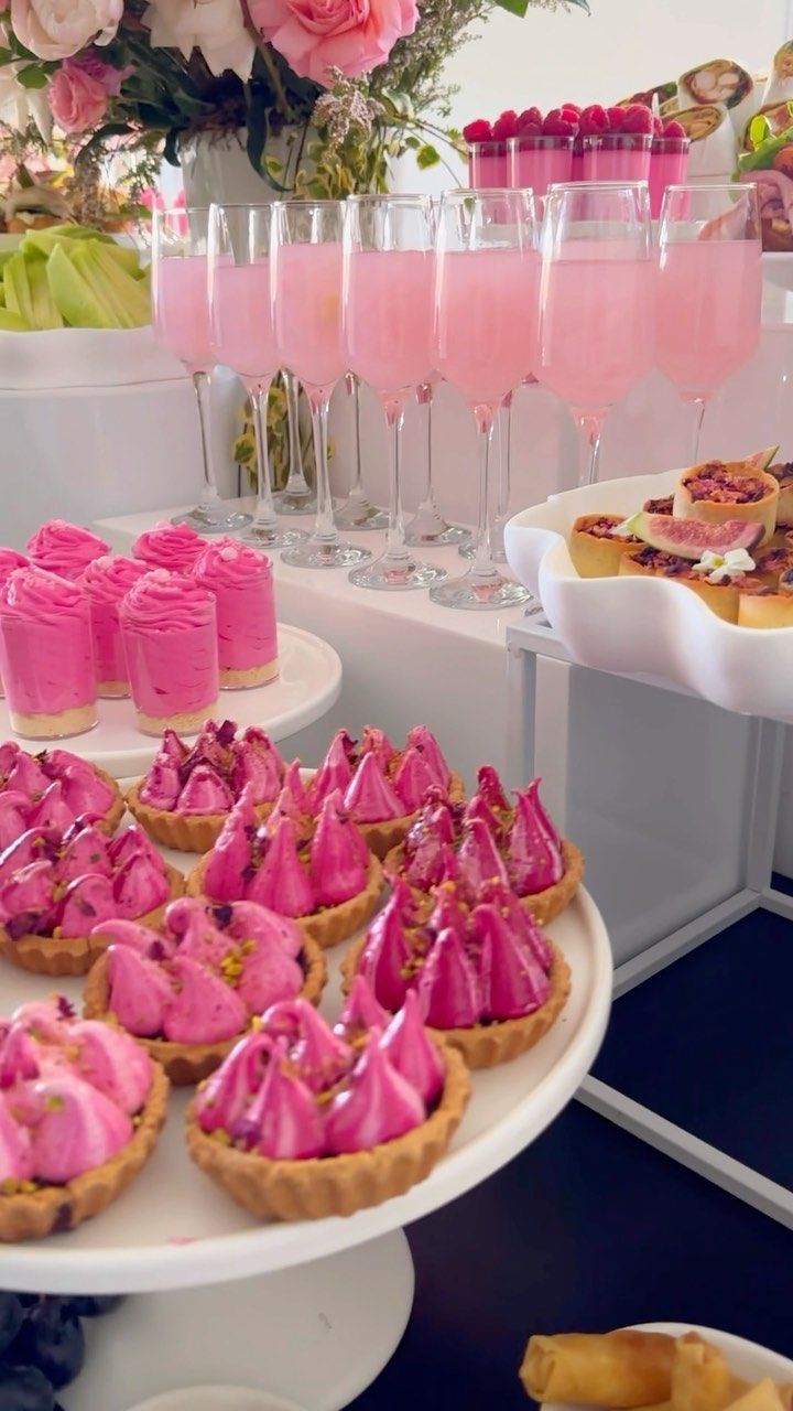 pink desserts and drinks are on display at a party