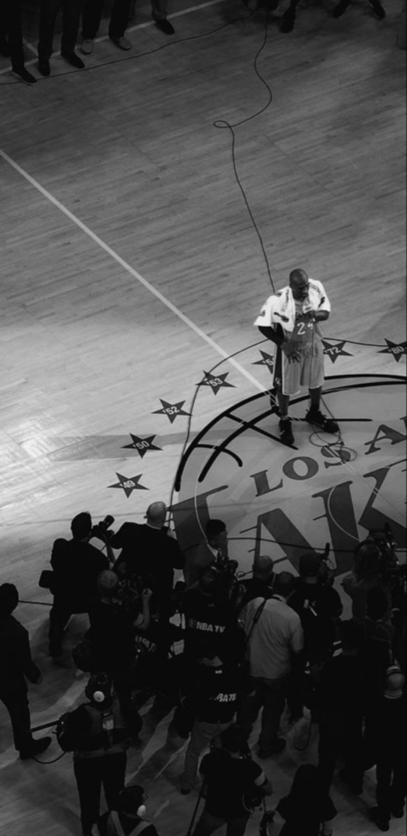 a man standing on top of a giant sign in front of a group of people