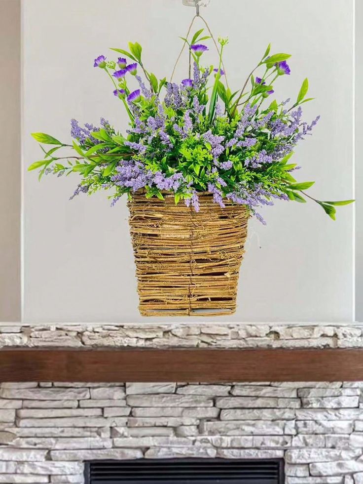 a basket filled with purple flowers sitting on top of a fireplace