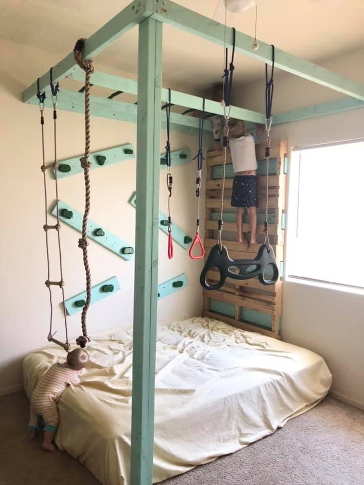 a child is playing on a bed made out of pallet boards and roped together