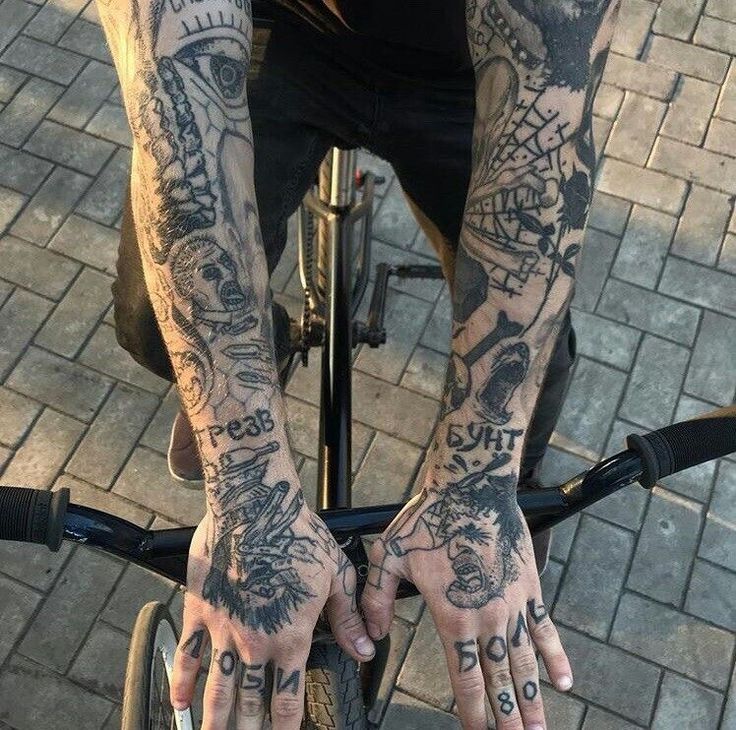 a man with tattoos on his arms riding a bike