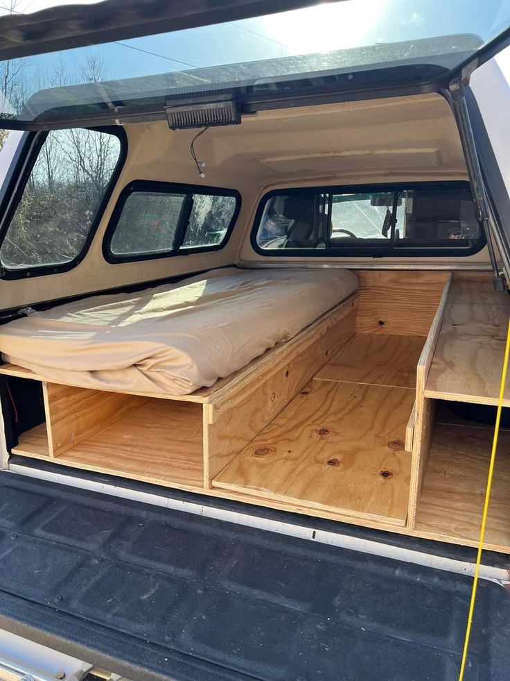 the back end of a pickup truck with its bed folded up and storage compartments open