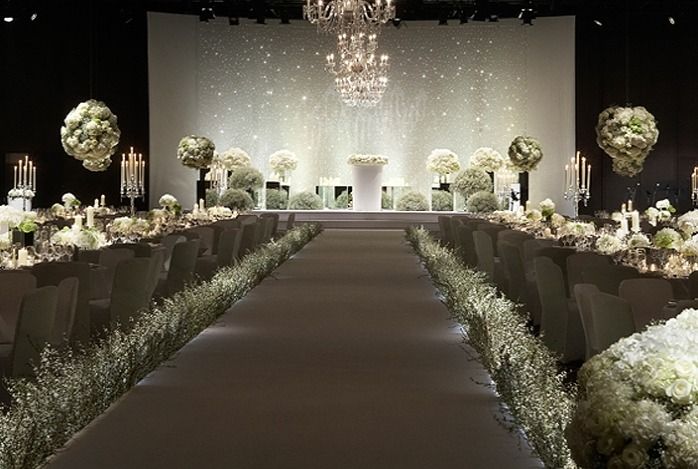 an elegant wedding set up with tall centerpieces and white flowers on the tables