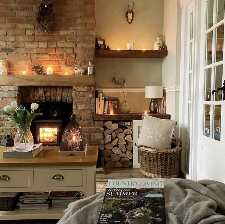 a living room filled with furniture and a fire place next to a brick fireplace covered in candles