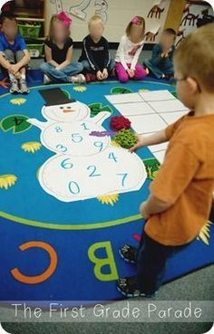 a group of children sitting on the floor in front of a blue rug with numbers