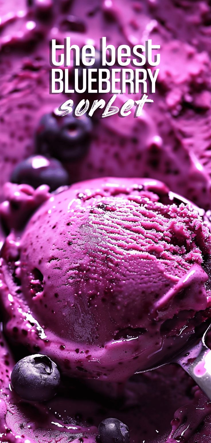 a scoop of blueberry ice cream on top of a bowl with spoons in it