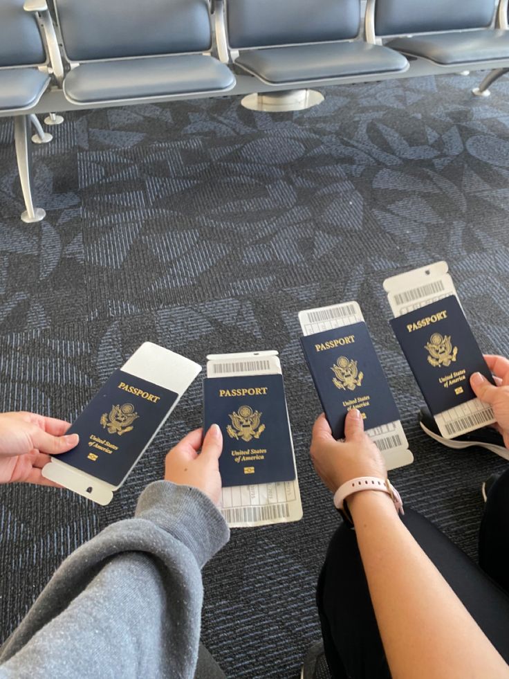 three people are holding their passports in each hand