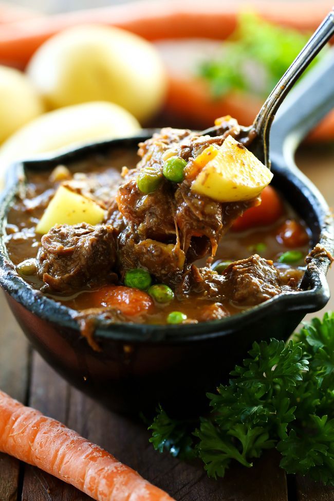 a spoon full of stew with potatoes and carrots